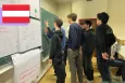 A group of young teenagers writing on a blackboard
