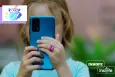 A young girl using a blue smartphone