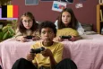 Two young girls and a young boy playing videogames and holding controllers