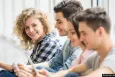Young people sitting on the floor with digital devices