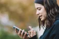 Teenage girl using a mobile device in an outside setting