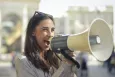 Young woman speaking through a loudspeaker