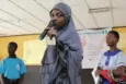 A young girl giving a speech in her classroom